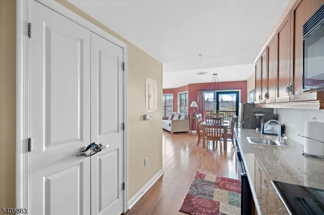 a view of a hallway with wooden floor and closet area