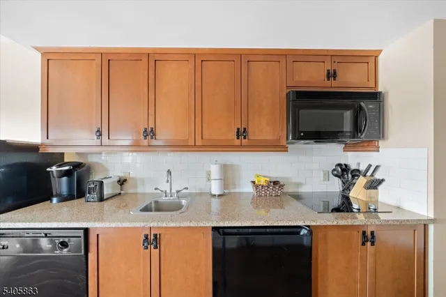 a kitchen with stainless steel appliances a sink dishwasher stove refrigerator and cabinets with wooden floor