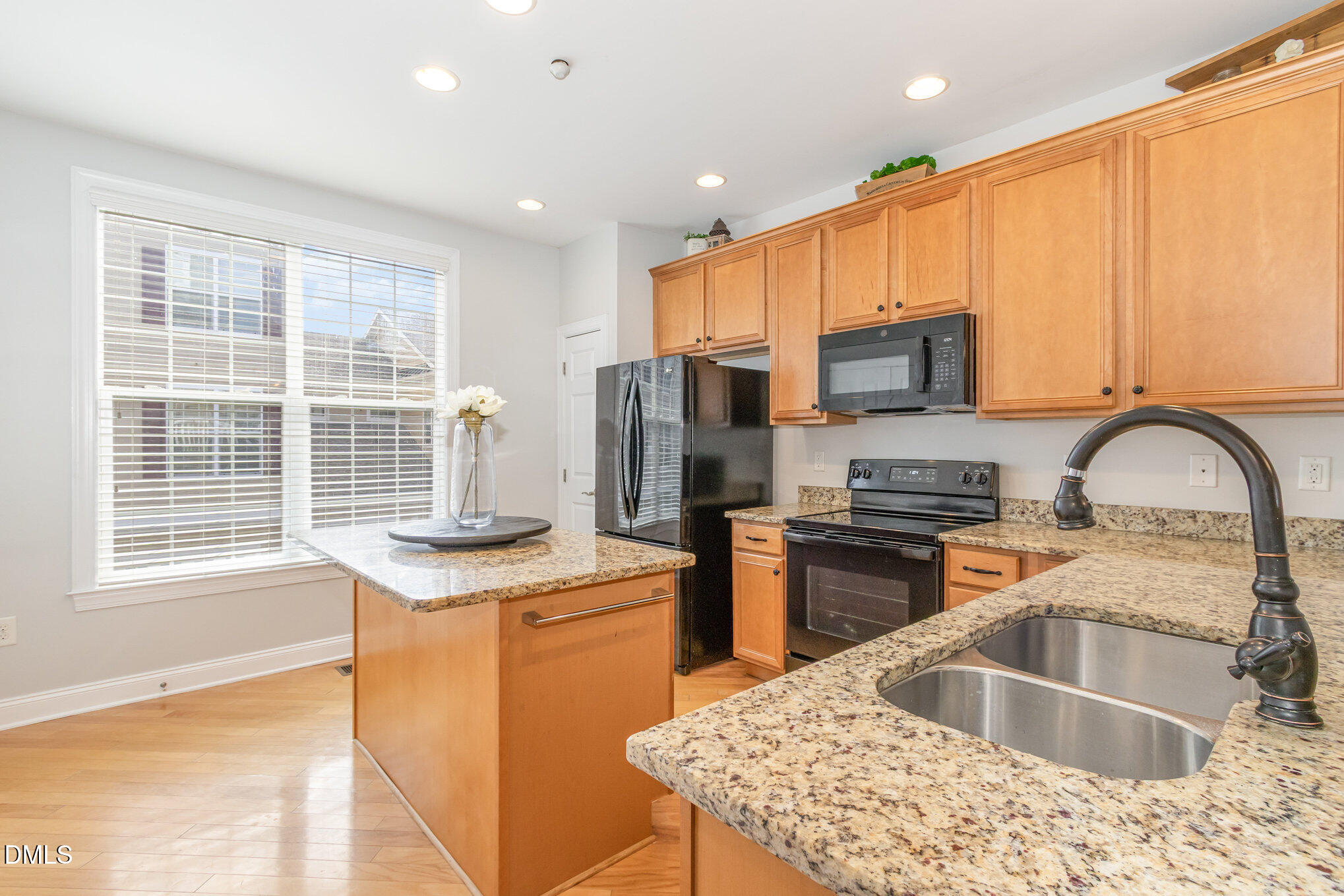 9211 Calabria Drive, Unit 117 Raleigh, NC 27617 - Photo 3 of 19 a kitchen with stainless steel appliances granite countertop a sink a stove and a refrigerator