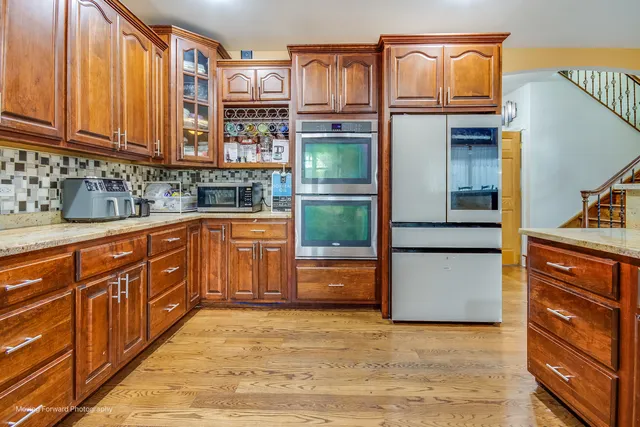 a kitchen with stainless steel appliances granite countertop a refrigerator and cabinets