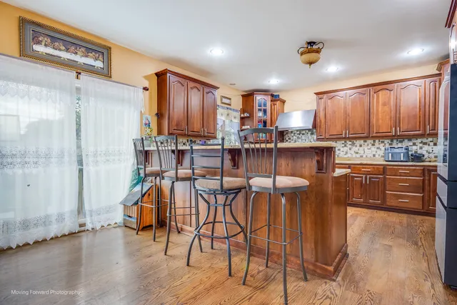 a kitchen with stainless steel appliances kitchen island granite countertop a table and chairs