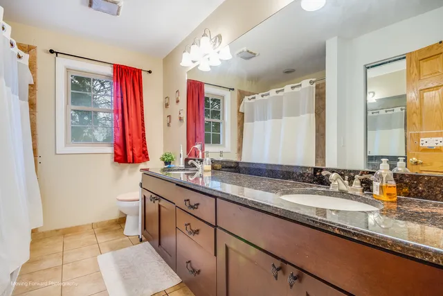 a bathroom with double vanity sinks a mirror and a bathtub