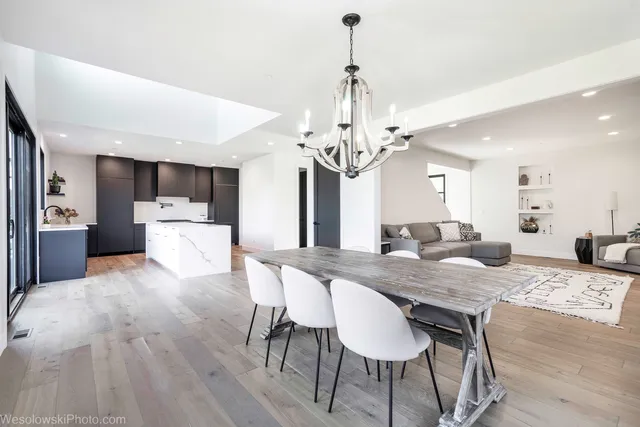 a view of a dining room and kitchen with a table chairs and chandelier