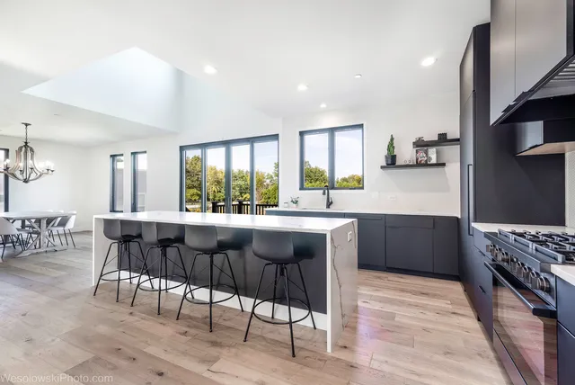 a kitchen with stainless steel appliances granite countertop table chairs sink and stove