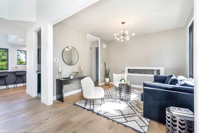 a living room with furniture a chandelier and a mirror