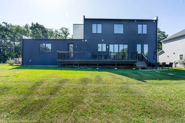 an aerial view of a house with a yard and a large tree