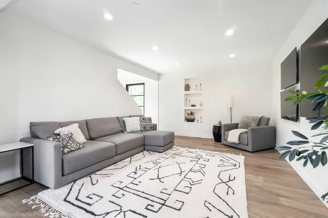 a living room with furniture wooden floor and a flat screen tv