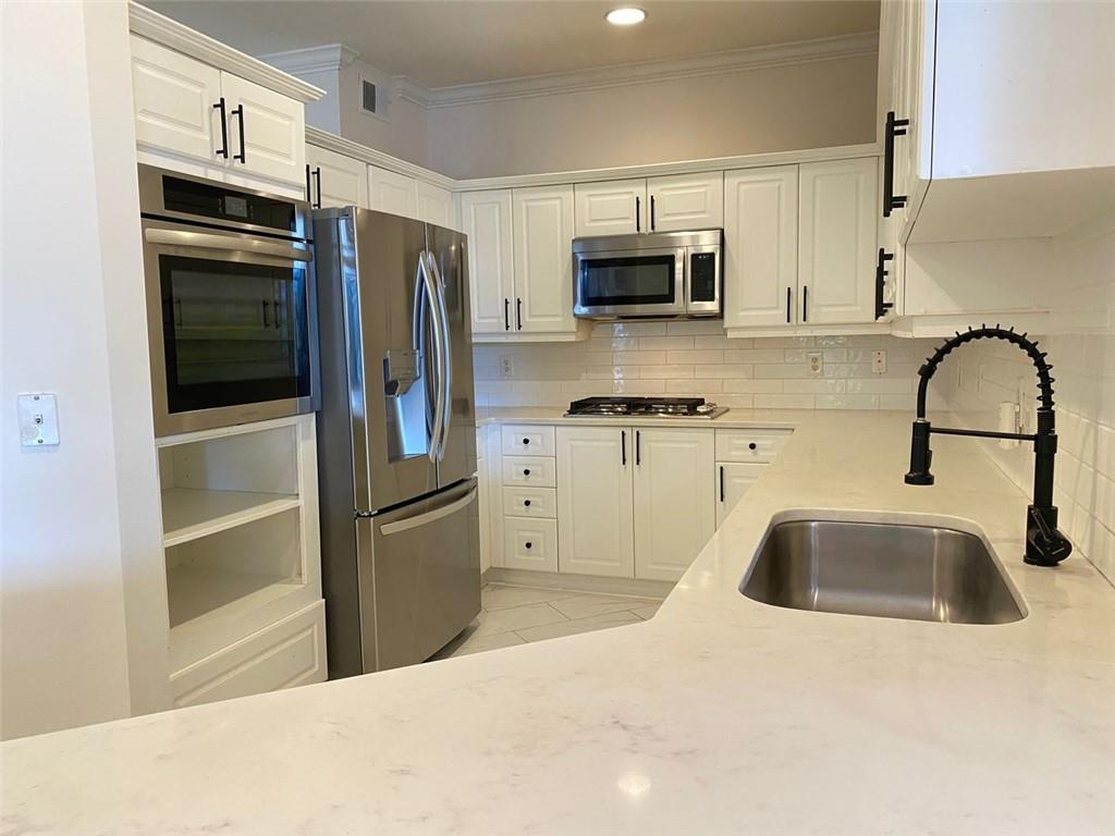 3047 Lenox Road Northeast, Unit 1202 Atlanta, GA 30324 - Photo 11 of 69 a kitchen with stainless steel appliances a refrigerator sink and microwave