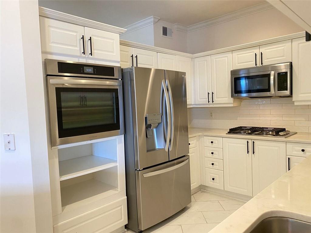 3047 Lenox Road Northeast, Unit 1202 Atlanta, GA 30324 - Photo 12 of 69 a kitchen with stainless steel appliances white cabinets and a refrigerator
