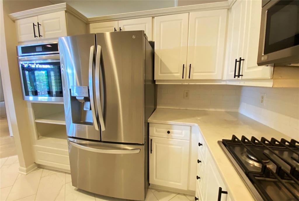 3047 Lenox Road Northeast, Unit 1202 Atlanta, GA 30324 - Photo 16 of 69 a kitchen with stainless steel appliances a refrigerator and a stove top oven