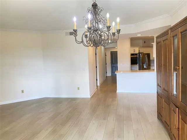 an empty room with wooden floor fireplace and windows