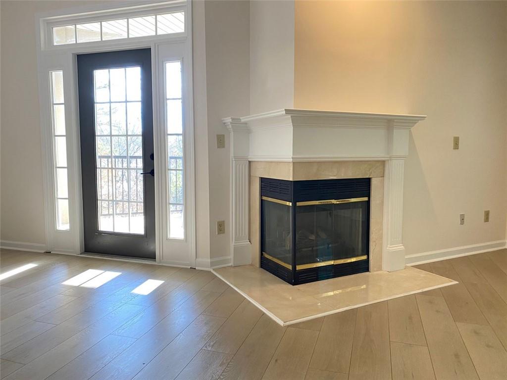 3047 Lenox Road Northeast, Unit 1202 Atlanta, GA 30324 - Photo 25 of 69 an empty room with wooden floor fireplace and windows