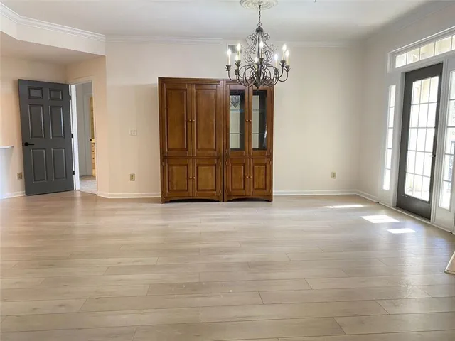 an empty room with closet and a chandelier fan