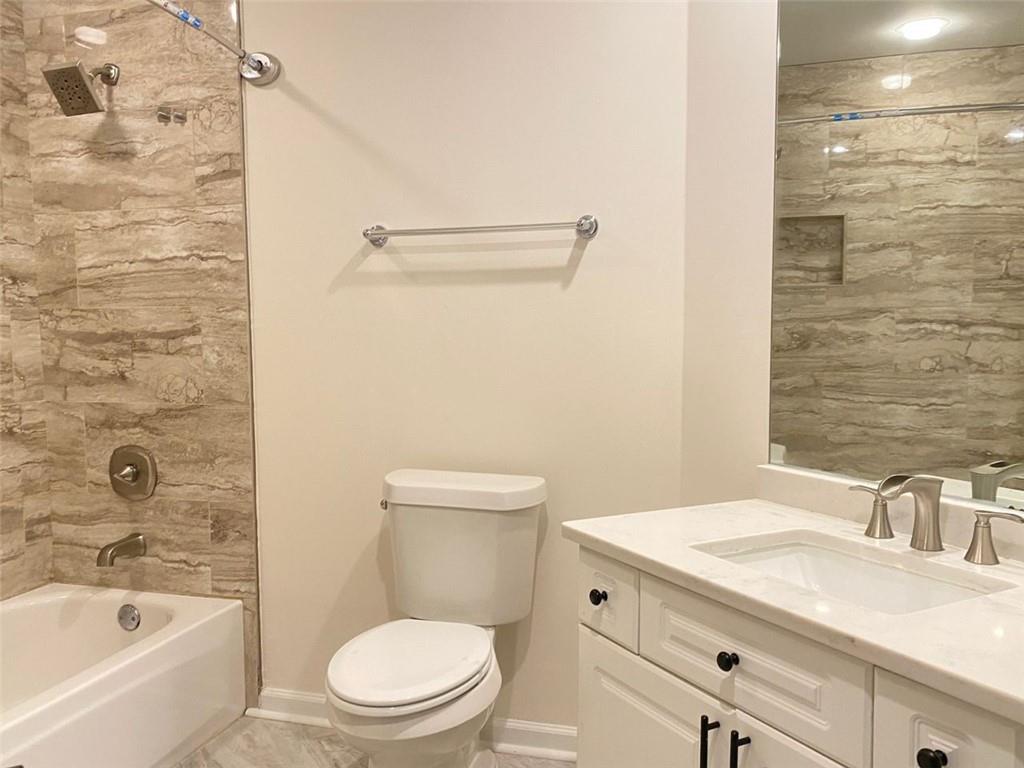 3047 Lenox Road Northeast, Unit 1202 Atlanta, GA 30324 - Photo 41 of 69 a bathroom with a granite countertop toilet a sink and bathtub