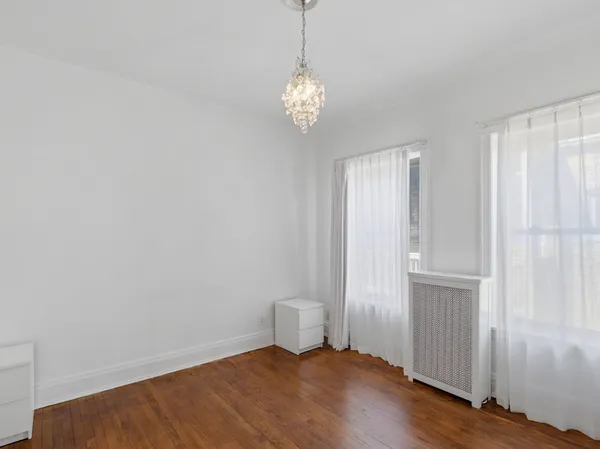 a view of a room with wooden floor and ceiling fan
