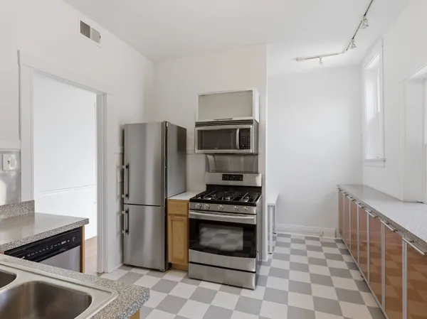 a kitchen with granite countertop a refrigerator and a sink