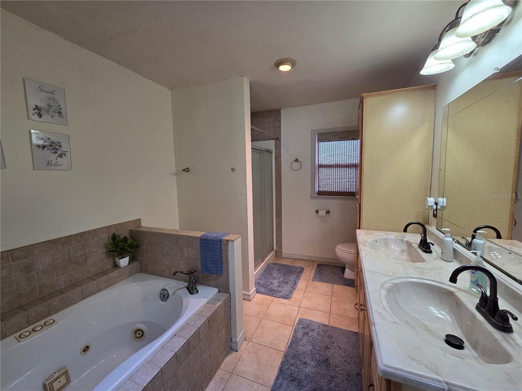 124 East F Street Frostproof, FL 33843 - Photo 26 of 37 a bathroom with a tub sink and mirror