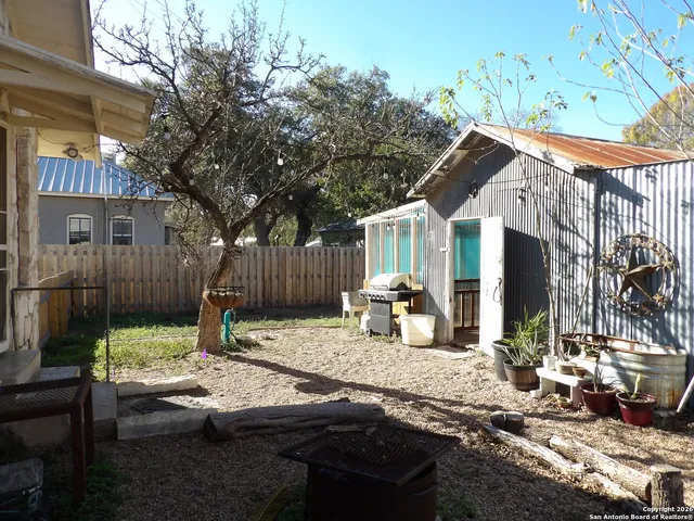 a backyard of a house with barbeque oven and outdoor seating