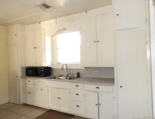a kitchen with white cabinets and white appliances