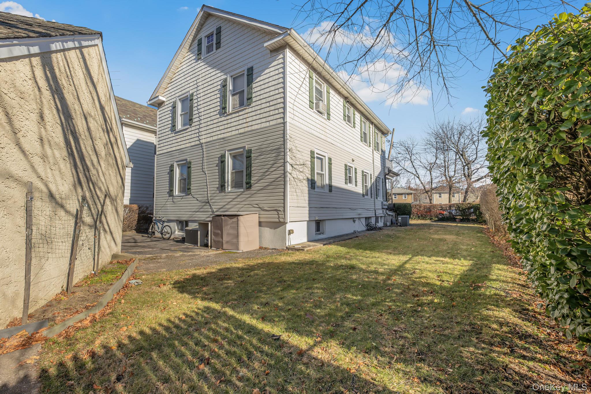 168 Stephenson Boulevard New Rochelle, NY 10801 - Photo 7 of 21 Rear view of house featuring a lawn