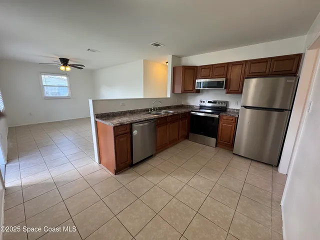 a kitchen with stainless steel appliances granite countertop a stove a refrigerator and a cabinets