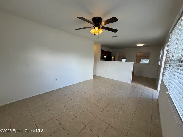 a view of a livingroom with a ceiling fan and window