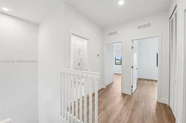 a view of a hallway with wooden floor