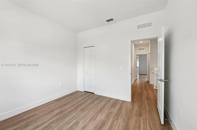 a view of a room with wooden floor