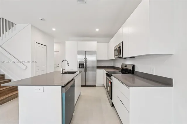a kitchen with stainless steel appliances granite countertop a sink stove and refrigerator
