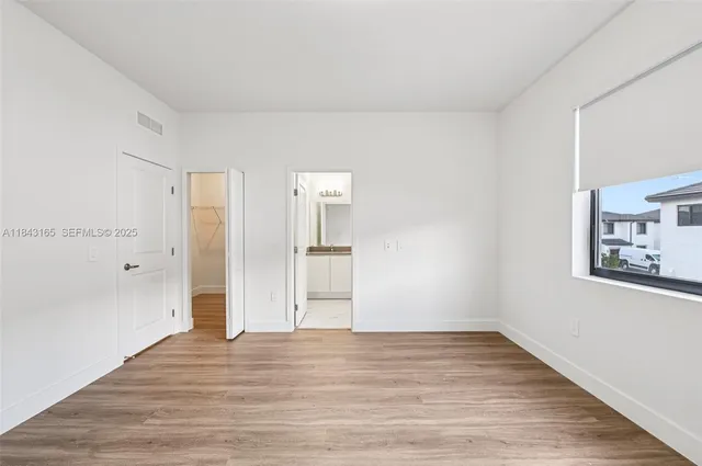 a view of empty room with wooden floor