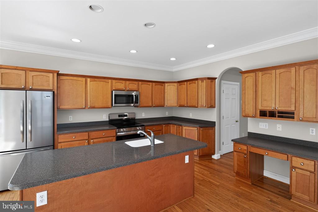 1604 Oriole Road Edgewater, MD 21037 - Photo 17 of 29 a kitchen with stainless steel appliances granite countertop a refrigerator a stove and a sink with wooden floor