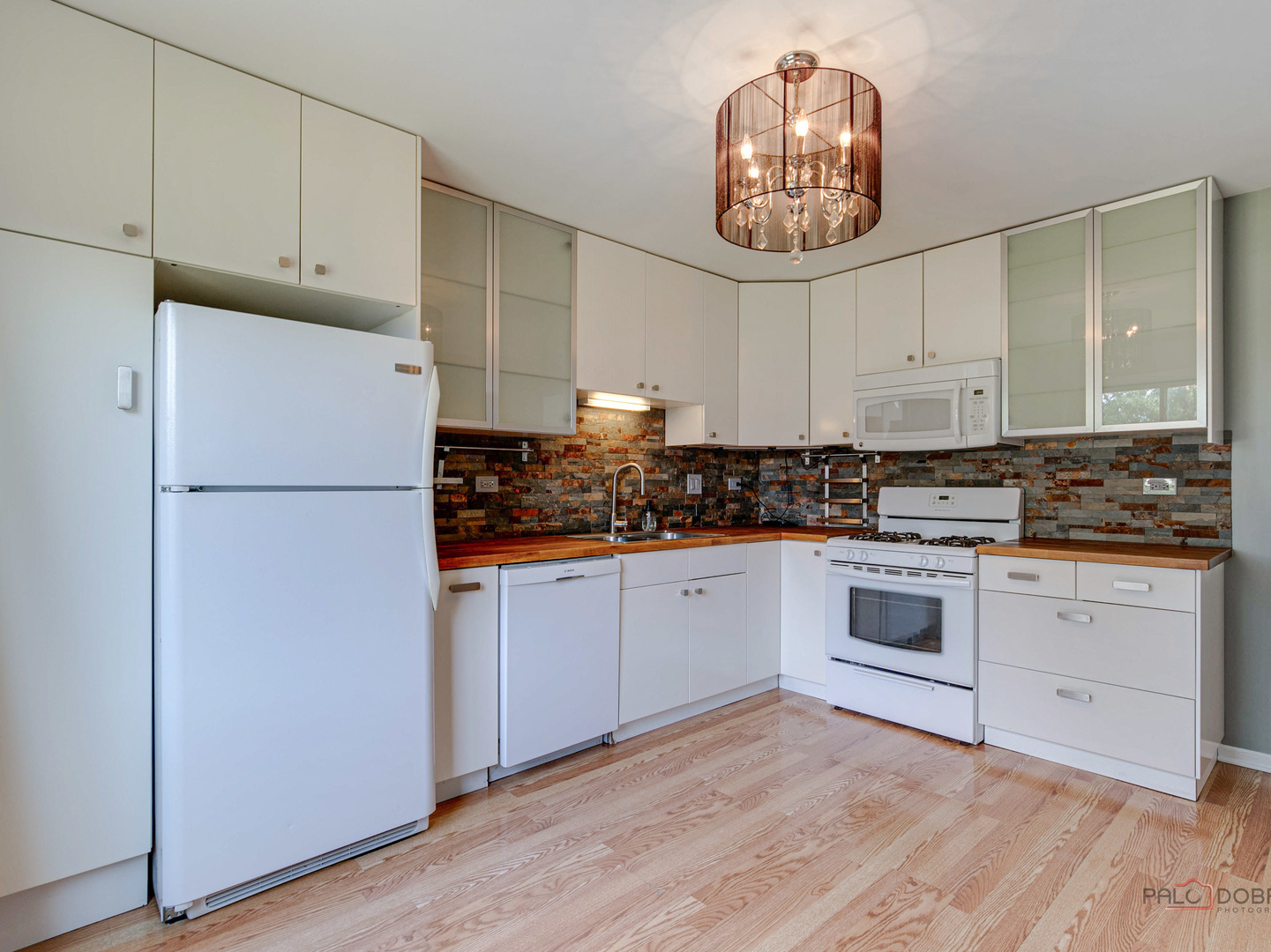 1082 Pine Tree Circle North, Unit 1082 Buffalo Grove, IL 60089 - Photo 13 of 26 a kitchen with a refrigerator and a stove top oven