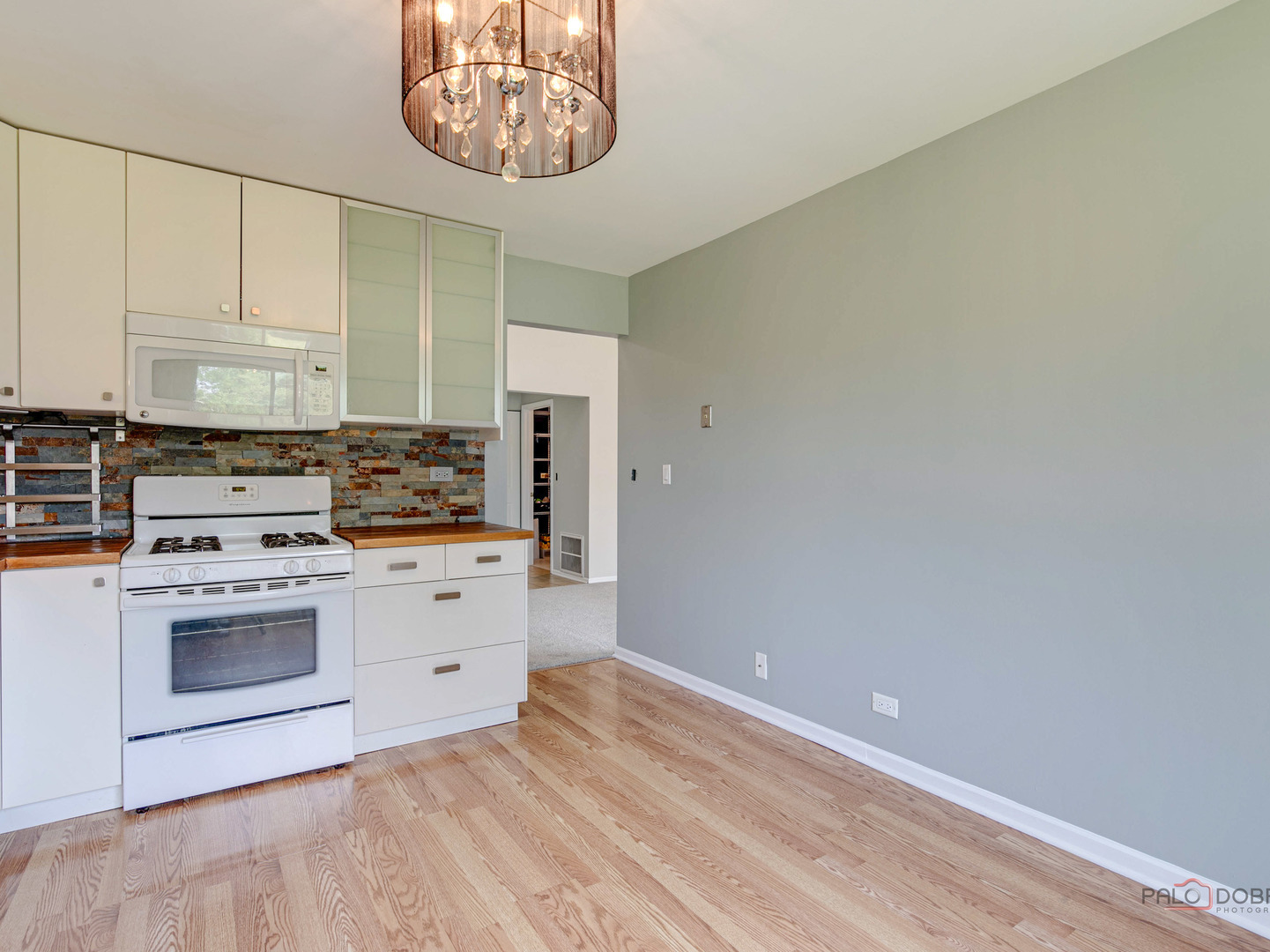 1082 Pine Tree Circle North, Unit 1082 Buffalo Grove, IL 60089 - Photo 14 of 26 a kitchen with a stove cabinets and a wooden floor