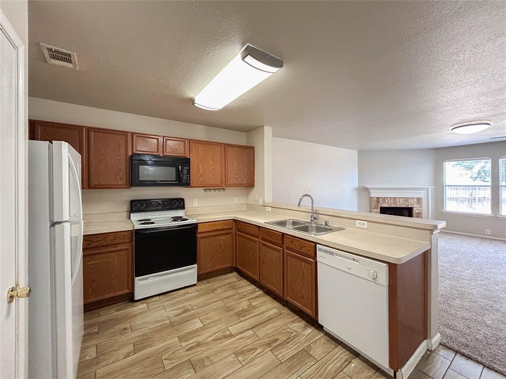 9013 Sagebrush Trail Cross Roads, TX 76227 - Photo 22 of 22 a kitchen with stainless steel appliances granite countertop a stove top oven a sink and dishwasher a refrigerator with wooden floor