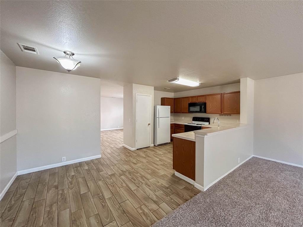 9013 Sagebrush Trail Cross Roads, TX 76227 - Photo 14 of 22 a kitchen with granite countertop a refrigerator and a stove top oven