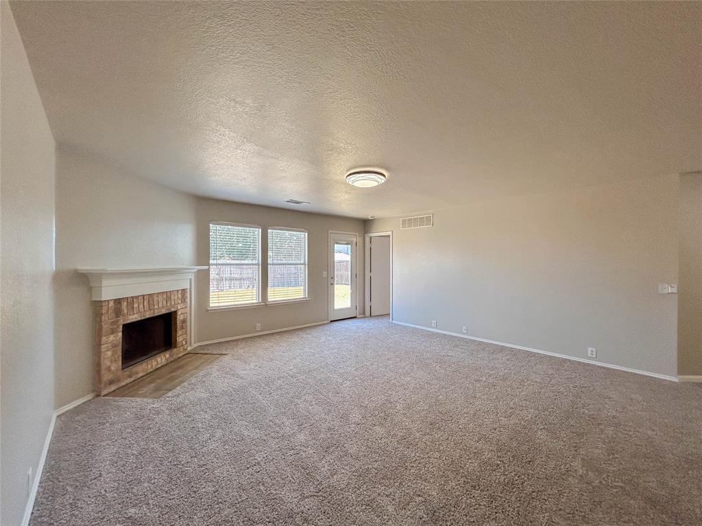 9013 Sagebrush Trail Cross Roads, TX 76227 - Photo 16 of 22 an empty room with fireplace and windows