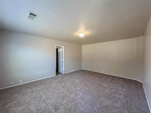 an empty room with fireplace and windows