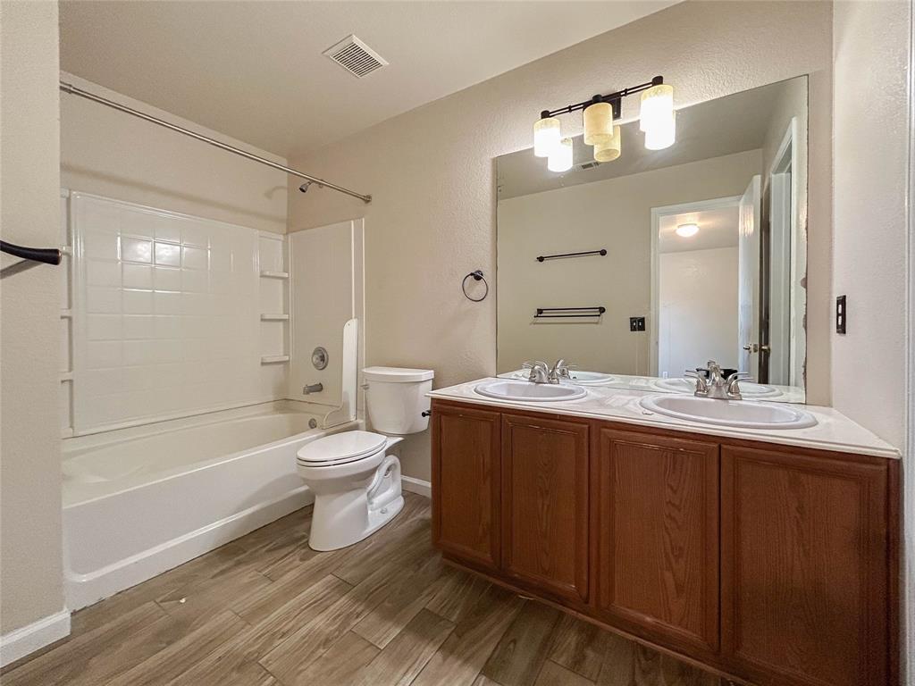 9013 Sagebrush Trail Cross Roads, TX 76227 - Photo 19 of 22 a bathroom with a granite countertop sink toilet a large mirror a bathtub and shower