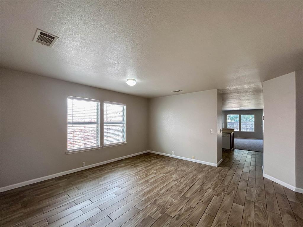 9013 Sagebrush Trail Cross Roads, TX 76227 - Photo 5 of 22 an empty room with wooden floor and windows