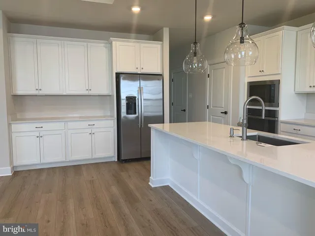 a large kitchen with granite countertop a sink stainless steel appliances and cabinets