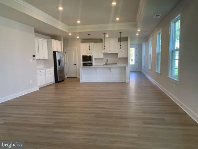 a view of kitchen with kitchen island granite countertop a large counter top stainless steel appliances and cabinets