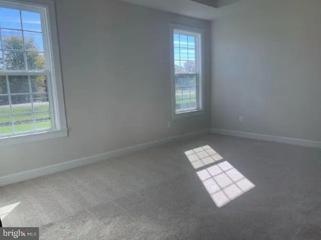 an empty room with windows and chandelier