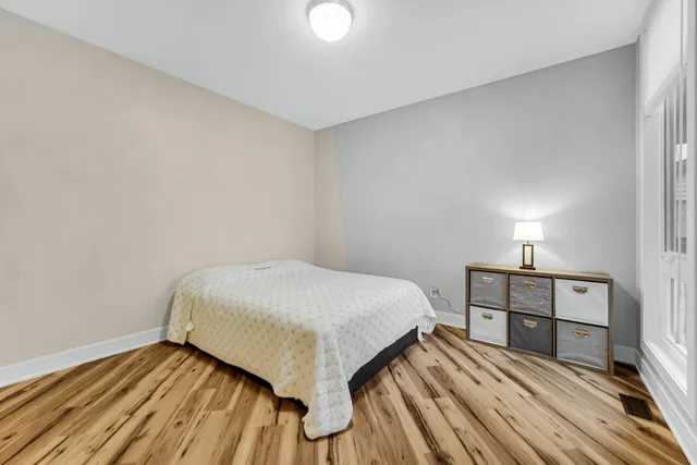 a bedroom with a bed and a lamp on desk