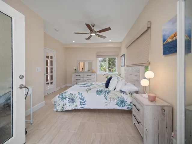 a view of a bedroom with a bed and wooden floor