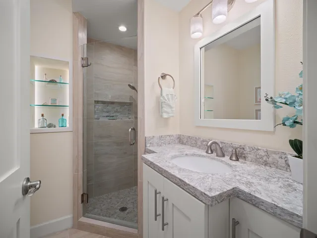 a bathroom with a granite countertop sink and a mirror
