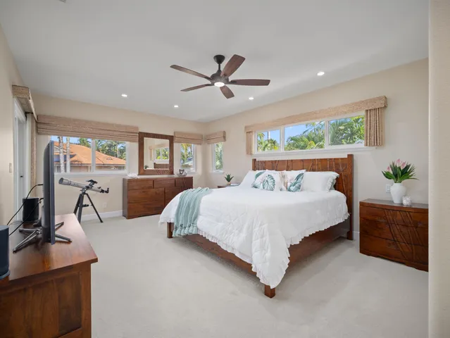 a spacious bedroom with a bed mirror and window