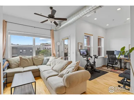 a living room with furniture a flat screen tv and a window