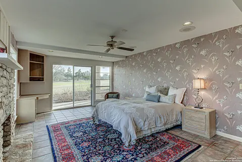 a spacious bedroom with a large bed a fireplace and windows