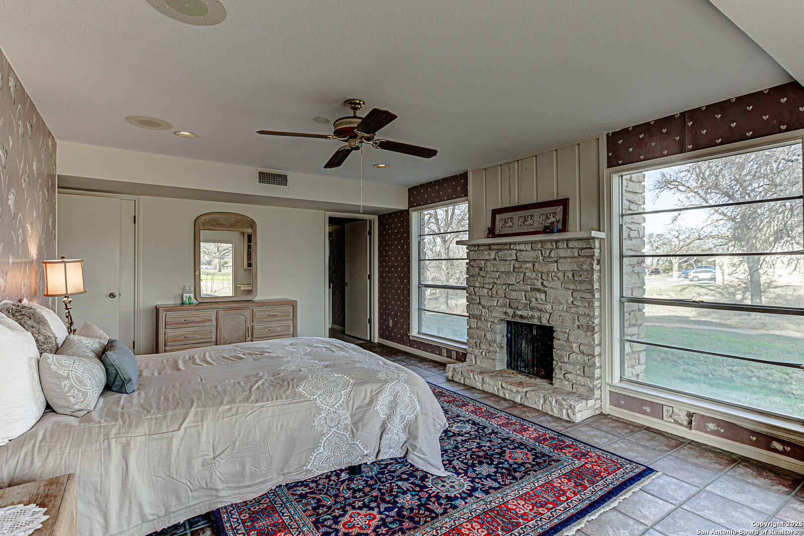 116 D Dawn, Unit D Horseshoe Bay, TX 78657 - Photo 22 of 43 a spacious bedroom with a large bed a fireplace and windows