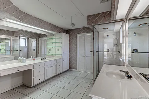 a bathroom with a double vanity sink toilet and mirror